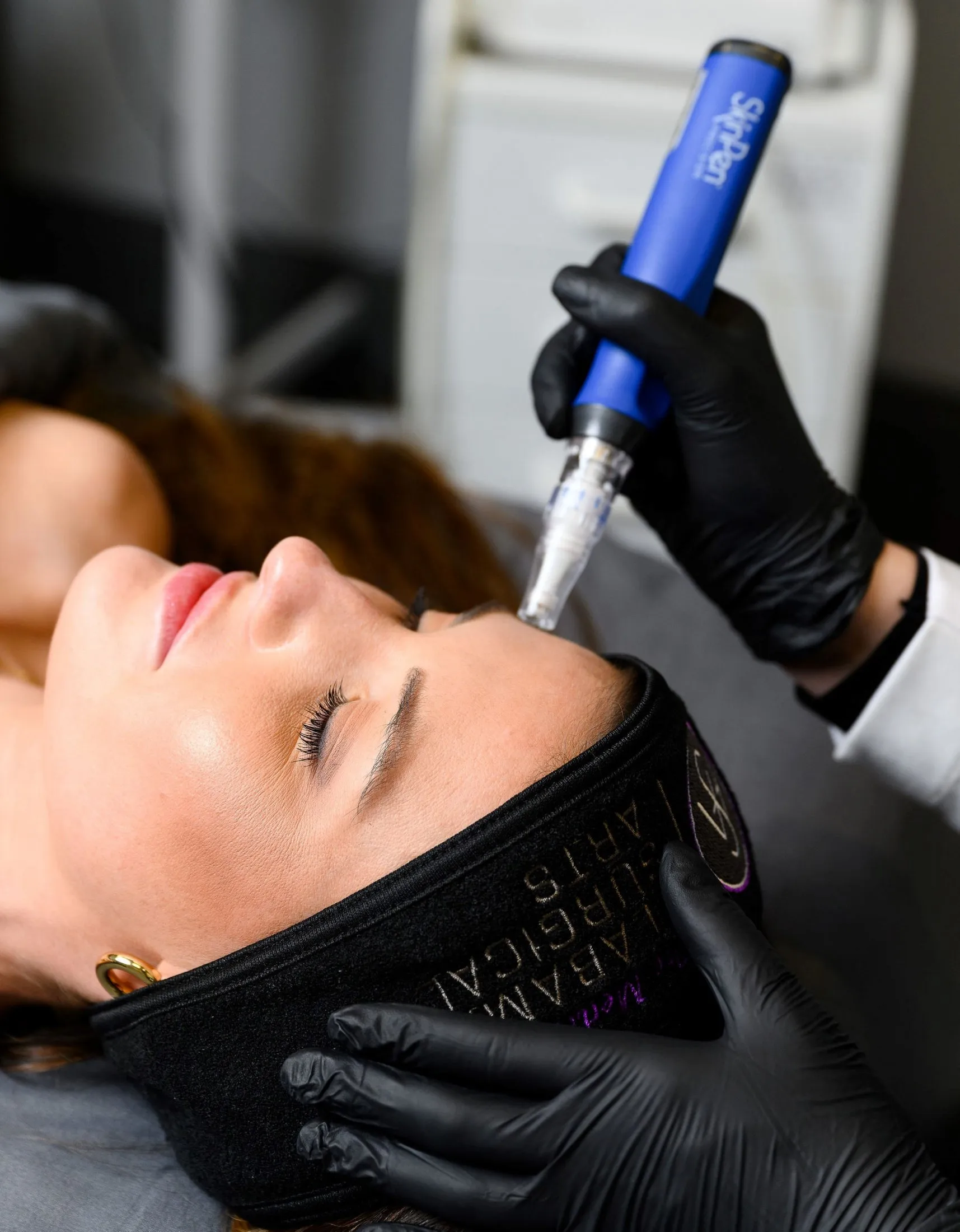 Woman receiving microneedling on her forehead 