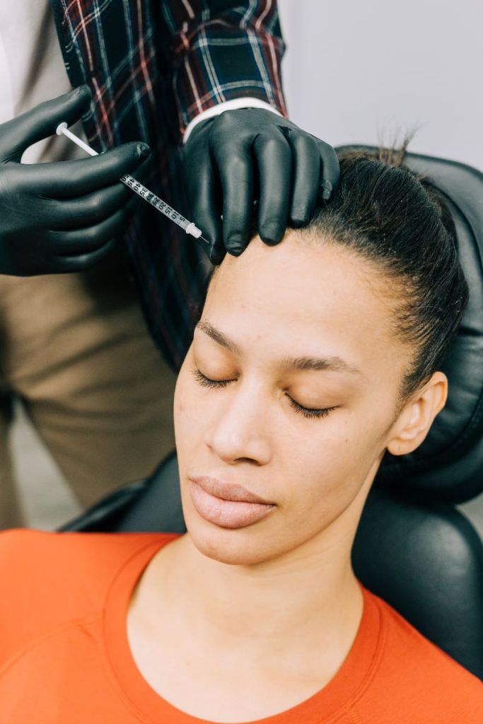 Woman receiving Neuromodulator injection in forehead