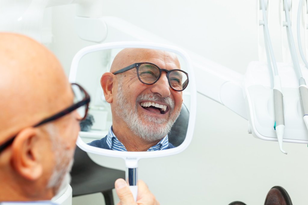 happy senior patient admiring his perfect teeth